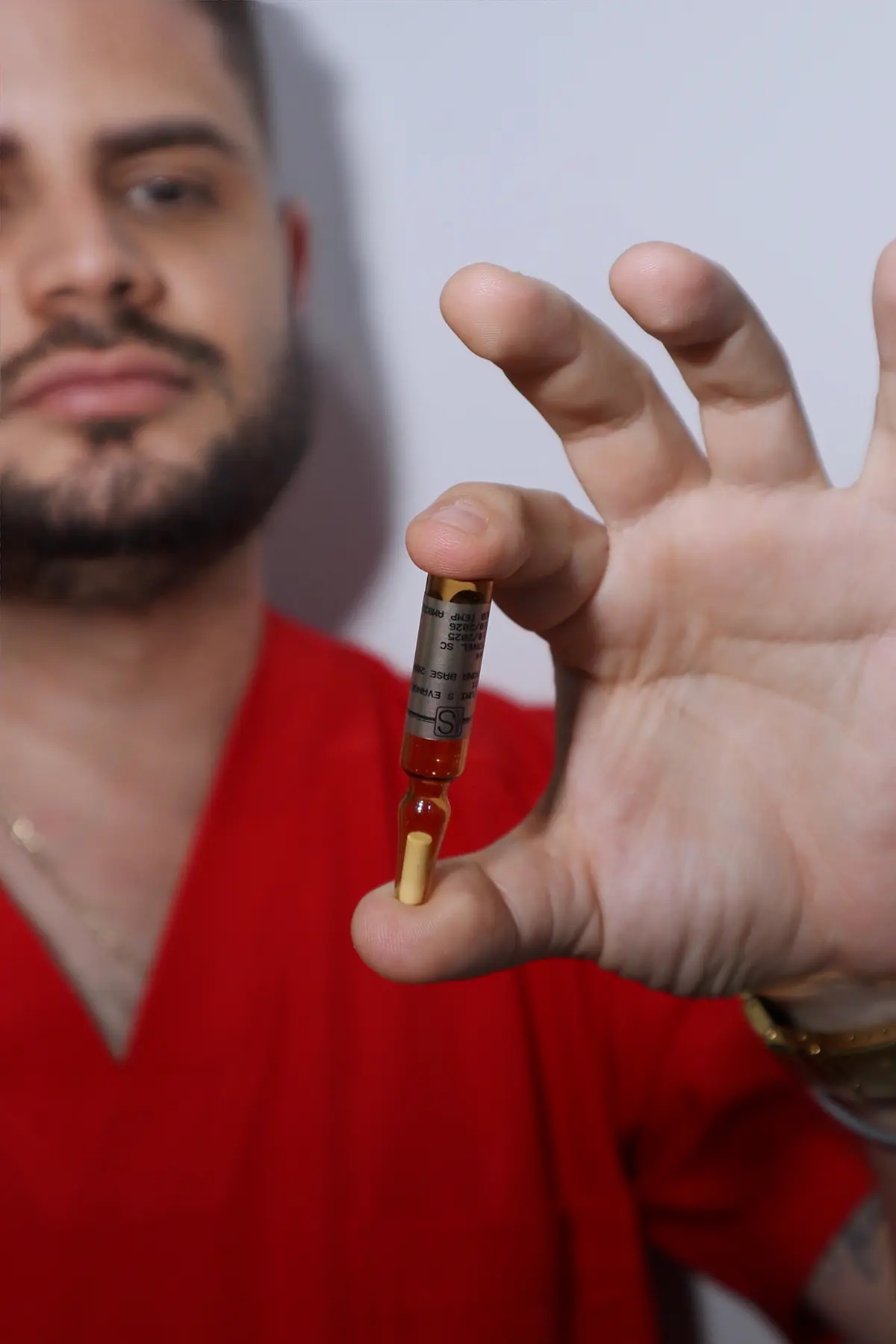 Dr. Marcos Rosales sosteniendo un vial